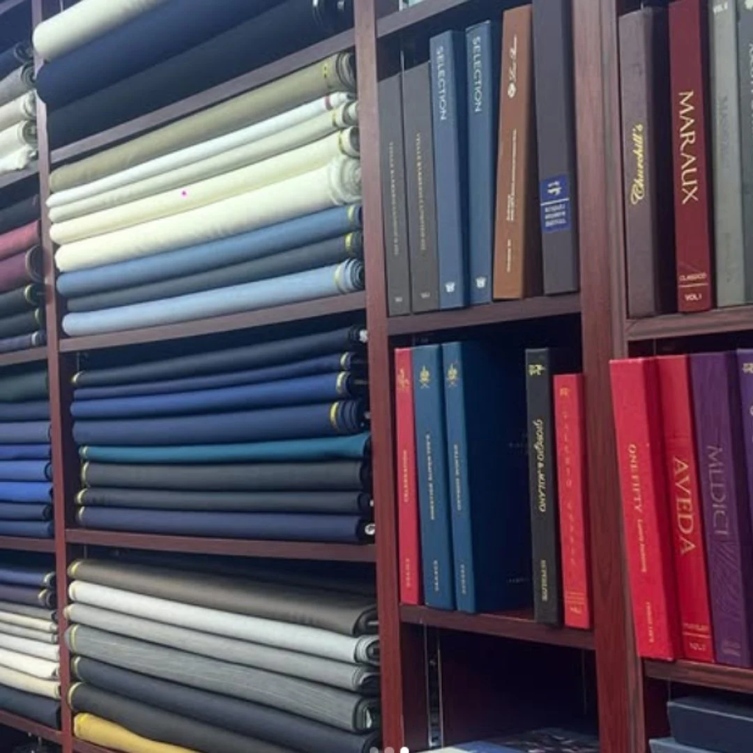 Tailor selecting premium wool fabrics showing Why Does Suit Fabric Matter More in suit craftsmanship.