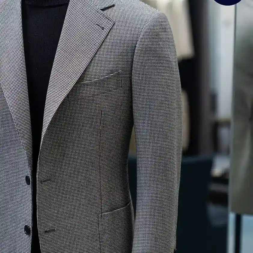 Tailor taking detailed measurements to explain what is a bespoke suit and how it is crafted from scratch.