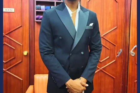 A professional tailor taking precise body measurements for a bespoke suit, showing how to choose the right tailor in Dubai for perfect fitting and craftsmanship.