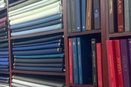 Tailor selecting premium wool fabrics showing Why Does Suit Fabric Matter More in suit craftsmanship.