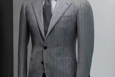 Tailor discussing fabric options and pricing to explain custom suit costs in Dubai during a personalized consultation.